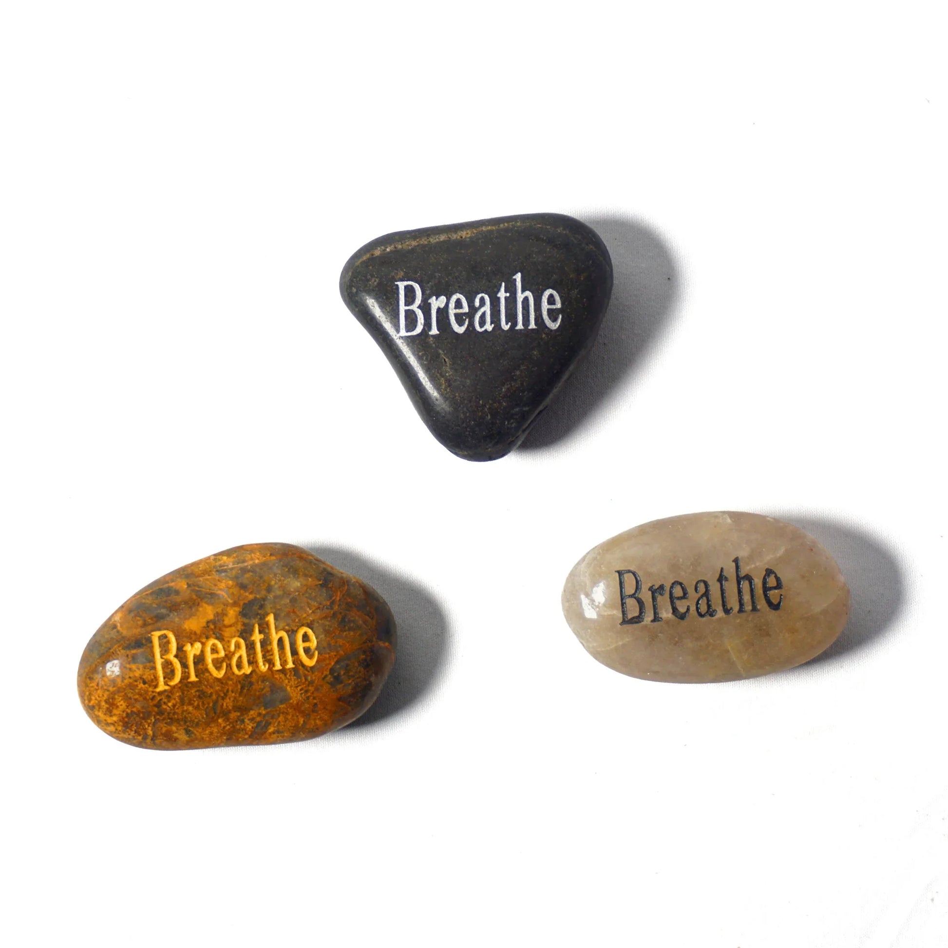 Three stones with 'Breathe' engraved on them on a white background