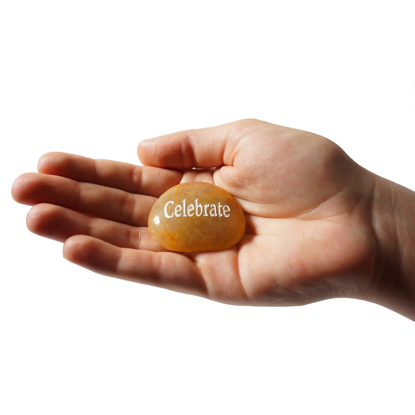 Hand holding a rock with 'Celebrate' engraved on it against a white background