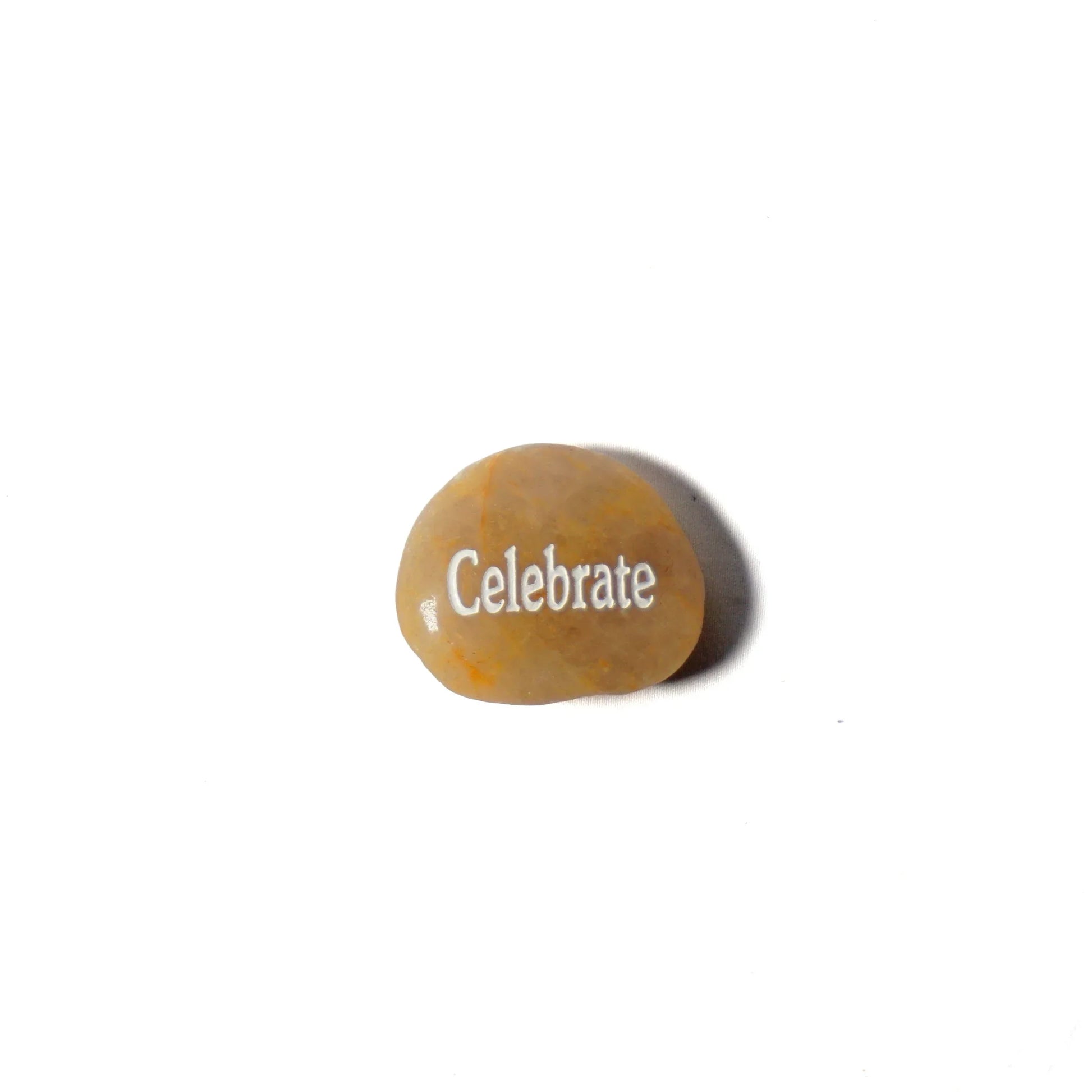 Round stone with 'Celebrate' engraved on a white background