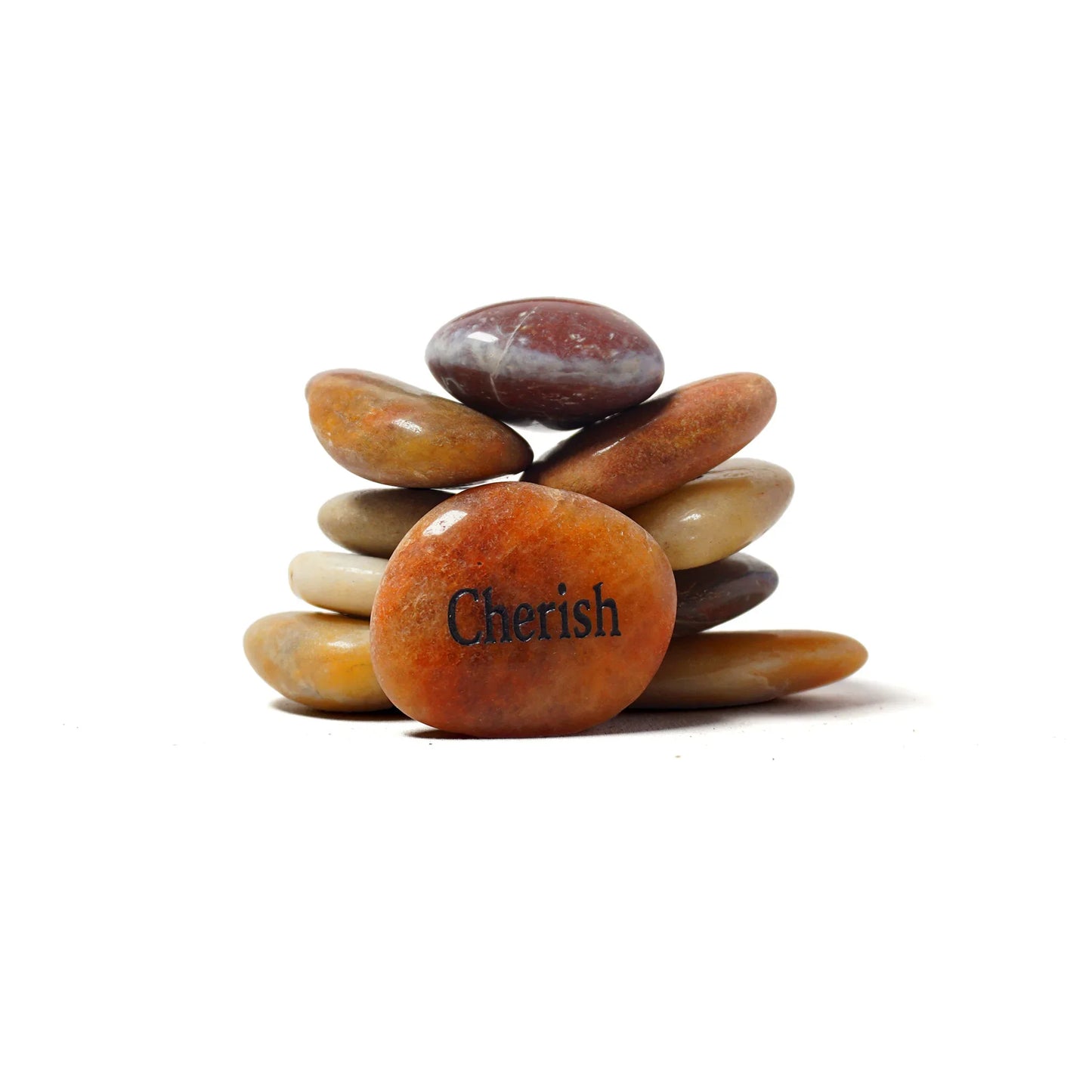 Stack of multicolored stones with 'Cherish' engraved on one stone against a white background