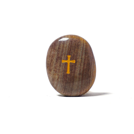 Brown stone with a gold cross on a white background