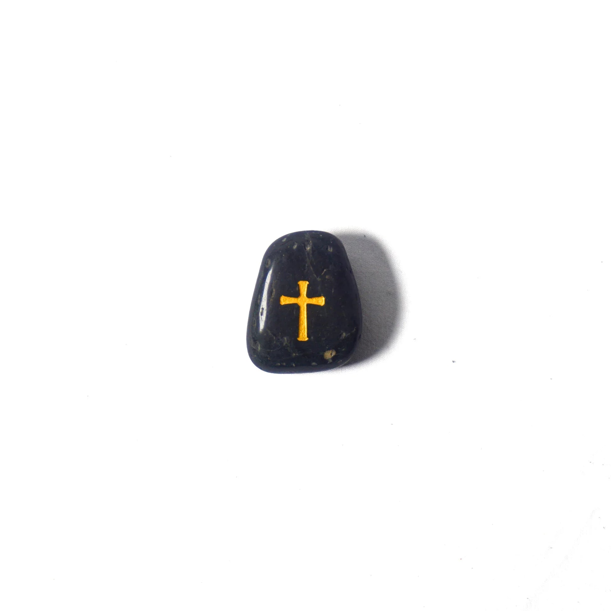 Black stone with a gold cross on a white background