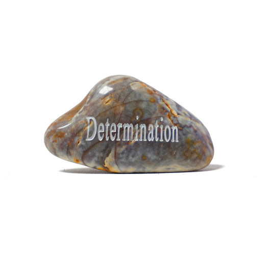 Decorative stone with 'Determination' engraved on a white background