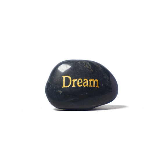 Black stone with 'Dream' engraved in gold on a white background