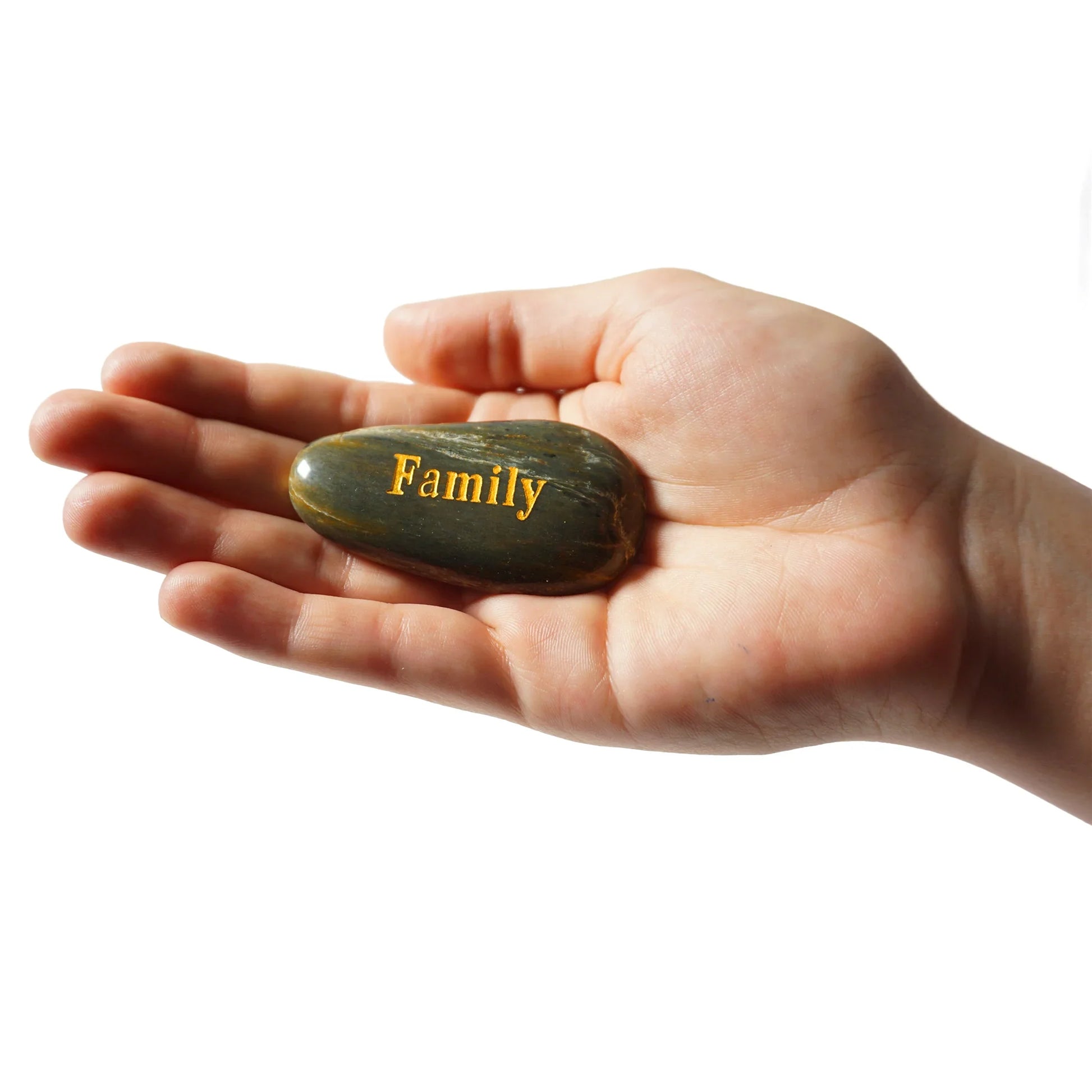 Hand holding a stone with 'Family' engraved on it against a white background