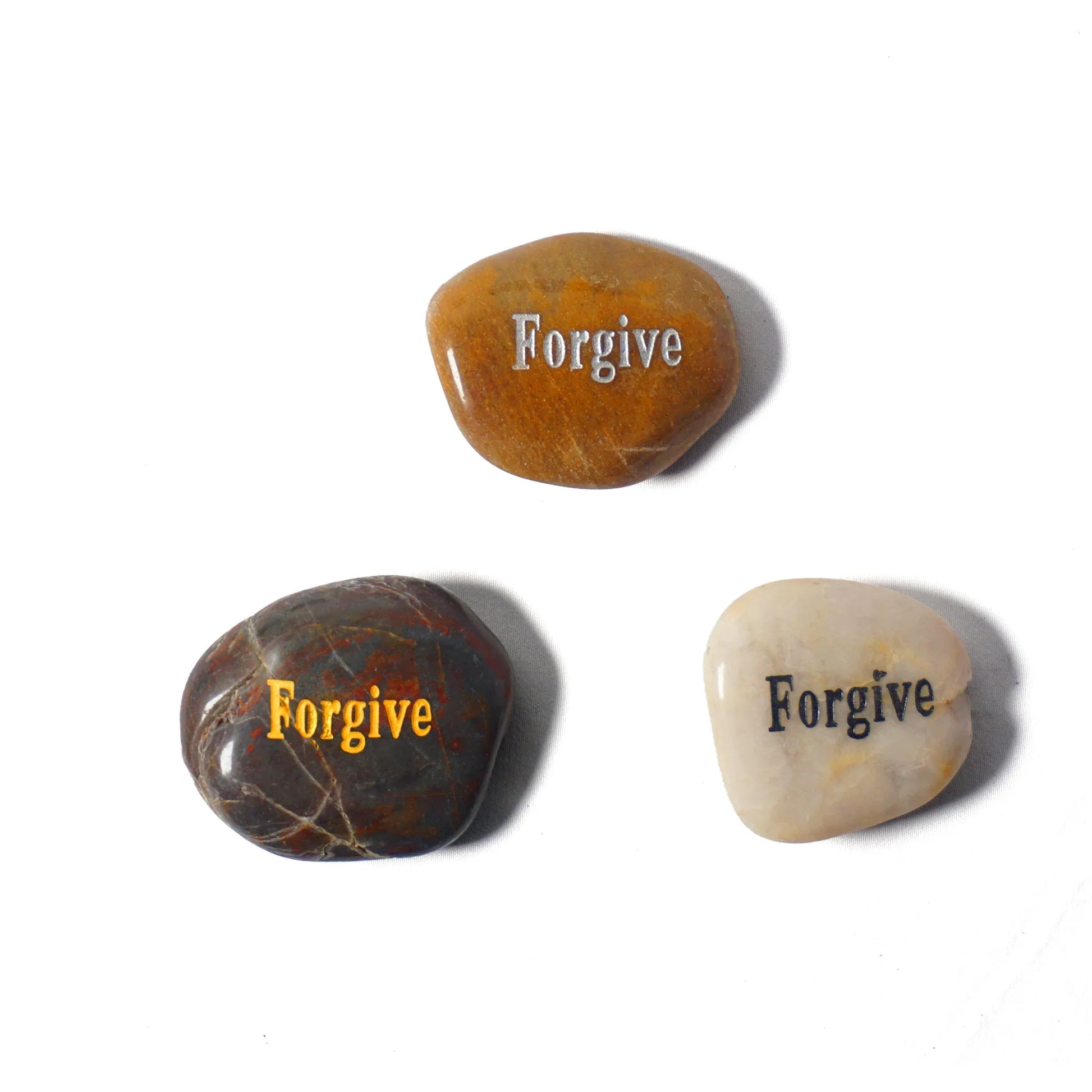 Three stones with 'Forgive' engraved on them on a white background
