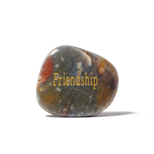 Decorative stone with 'Friendship' engraved on a white background