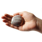 Hand holding a stone with 'God Bless America' engraved on a white background