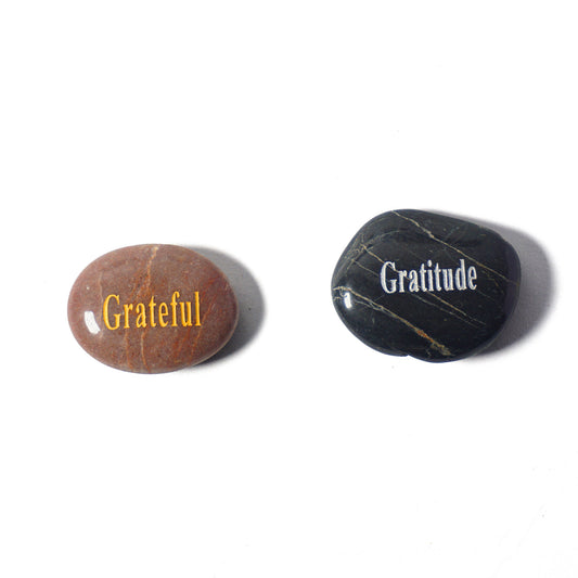 Two stones with 'Grateful' and 'Gratitude' text on a white background