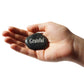 Hand holding a stone with 'Grateful' engraved on it against a white background