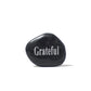Black stone with 'Grateful' engraved on a white background