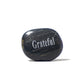 Black stone with 'Grateful' engraved on a white background