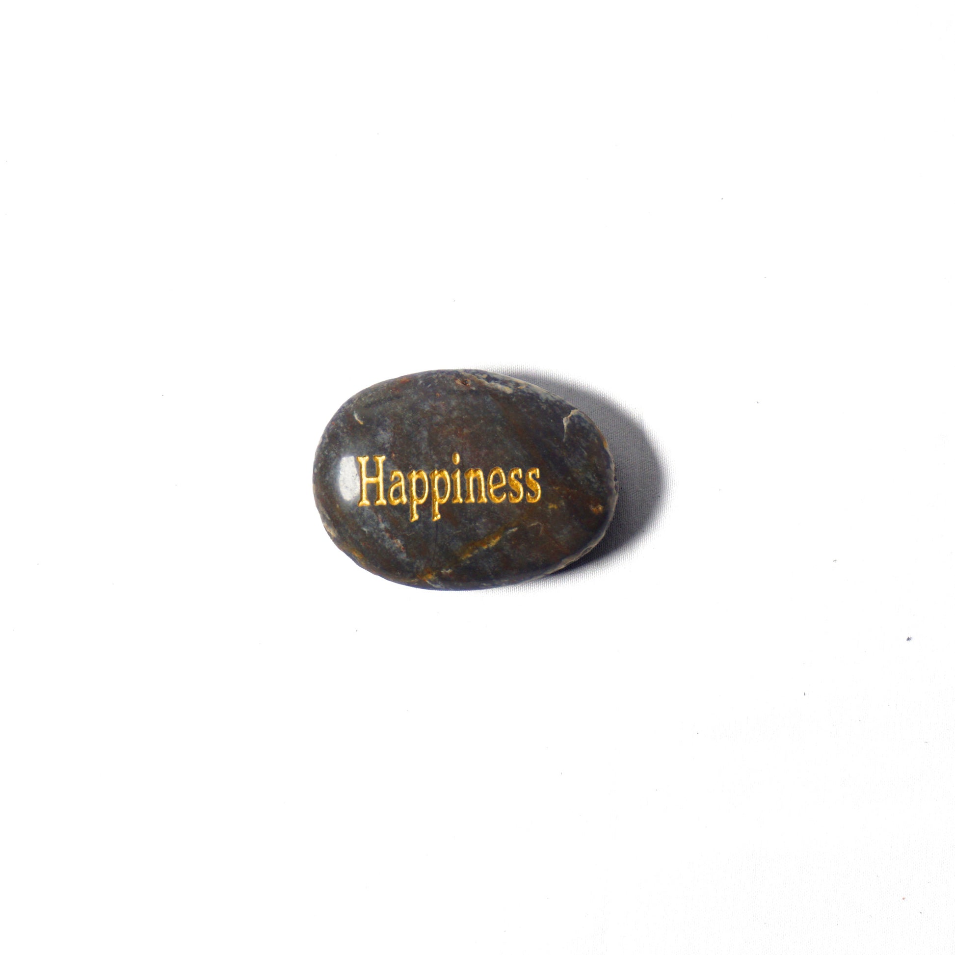 Rounded stone with 'Happiness' engraved on a white background