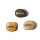 Three stones with 'Happiness' engraved on them on a white background