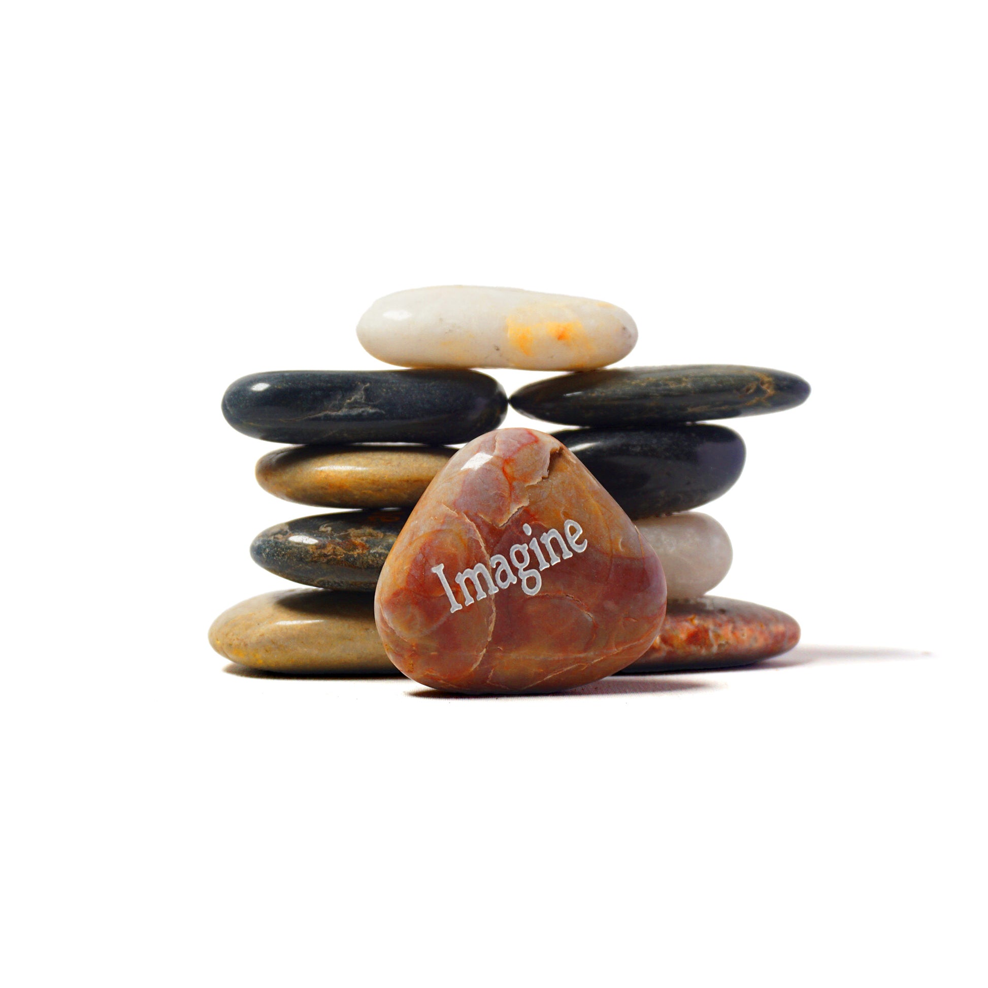 Stack of stones with a heart-shaped rock labeled 'Imagine' on a white background