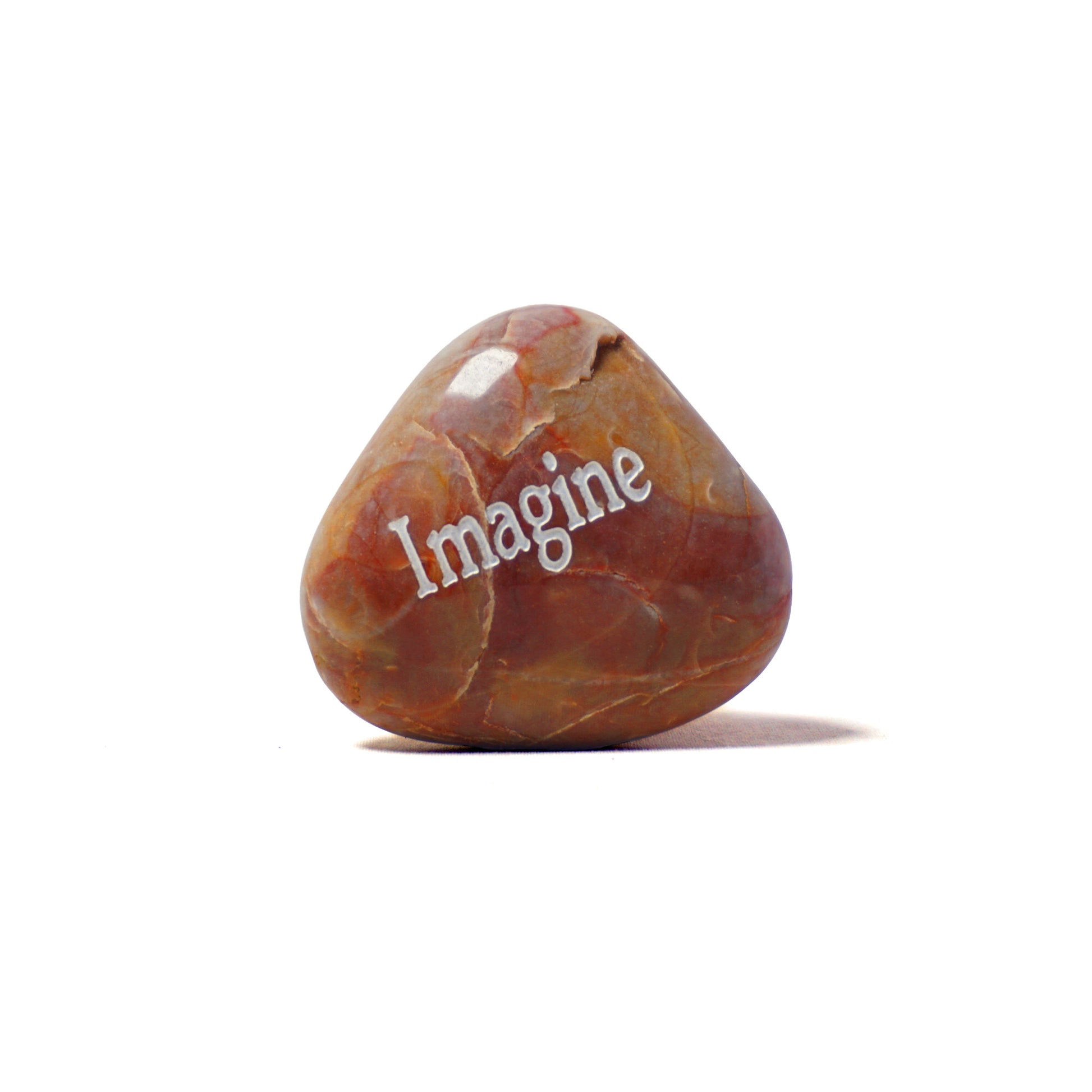 Brown stone with 'Imagine' engraved on a white background