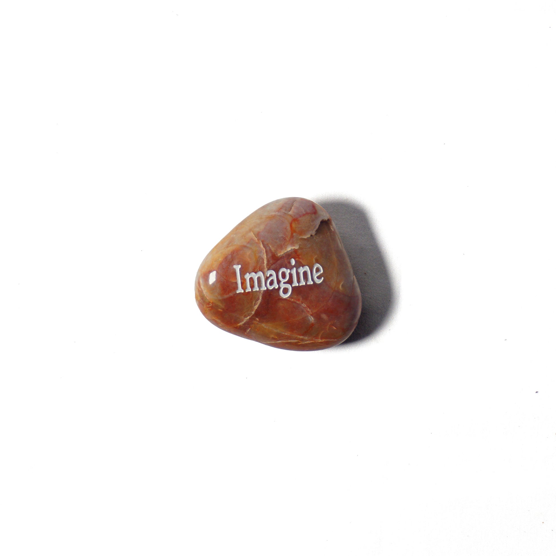 Brown stone with 'Imagine' engraved on a white background