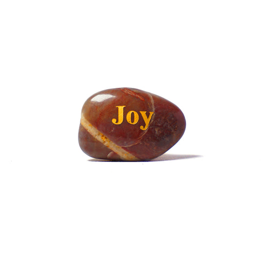 Brown stone with 'Joy' engraved on a white background