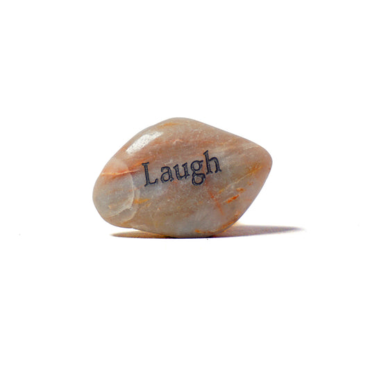 Decorative stone with 'Laugh' engraved on a white background