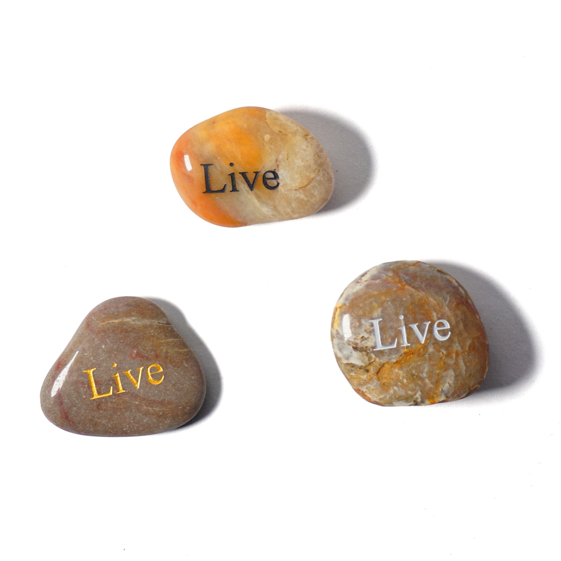 Three stones with 'Live' engraved on them on a white background