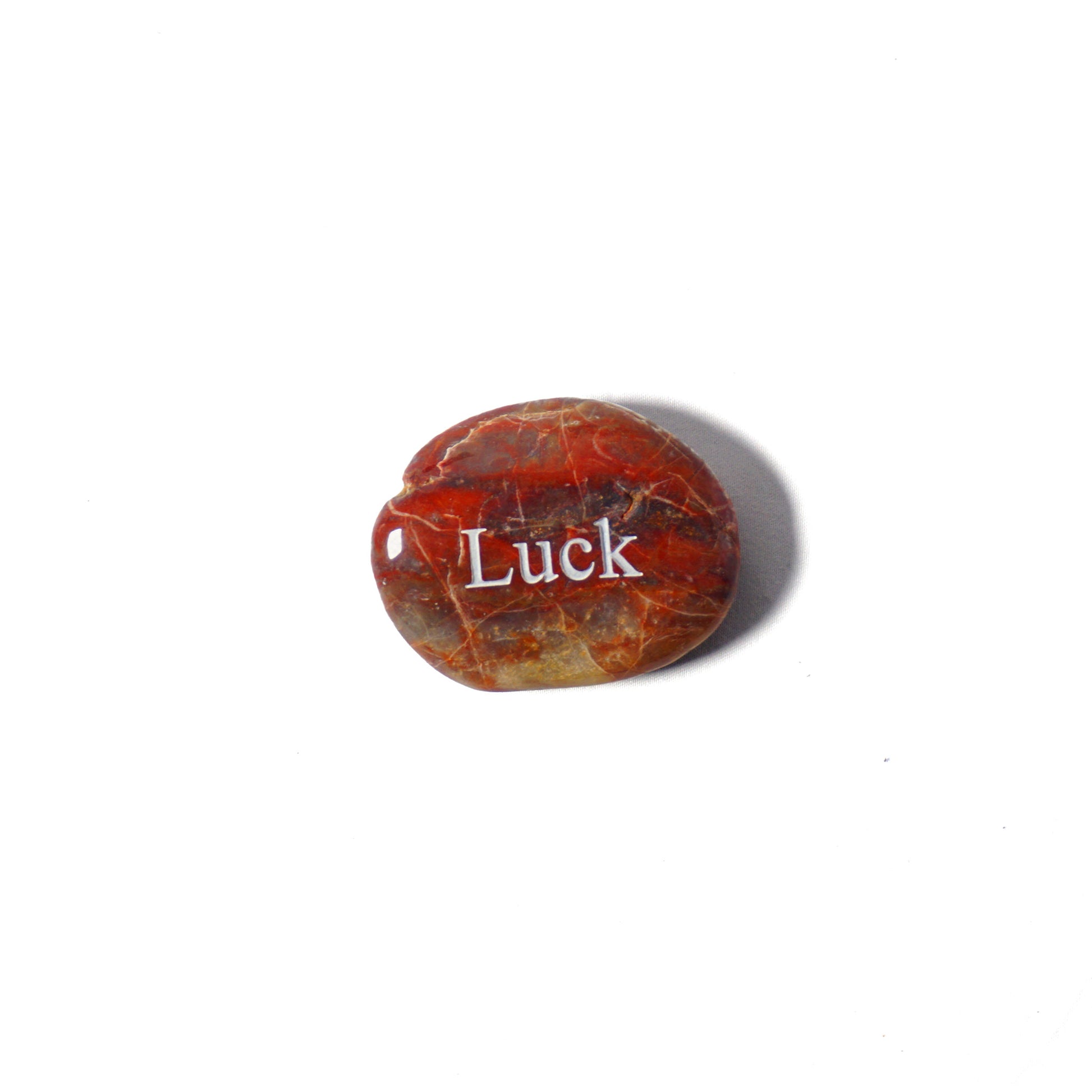 Brown stone with 'Luck' engraved on a white background