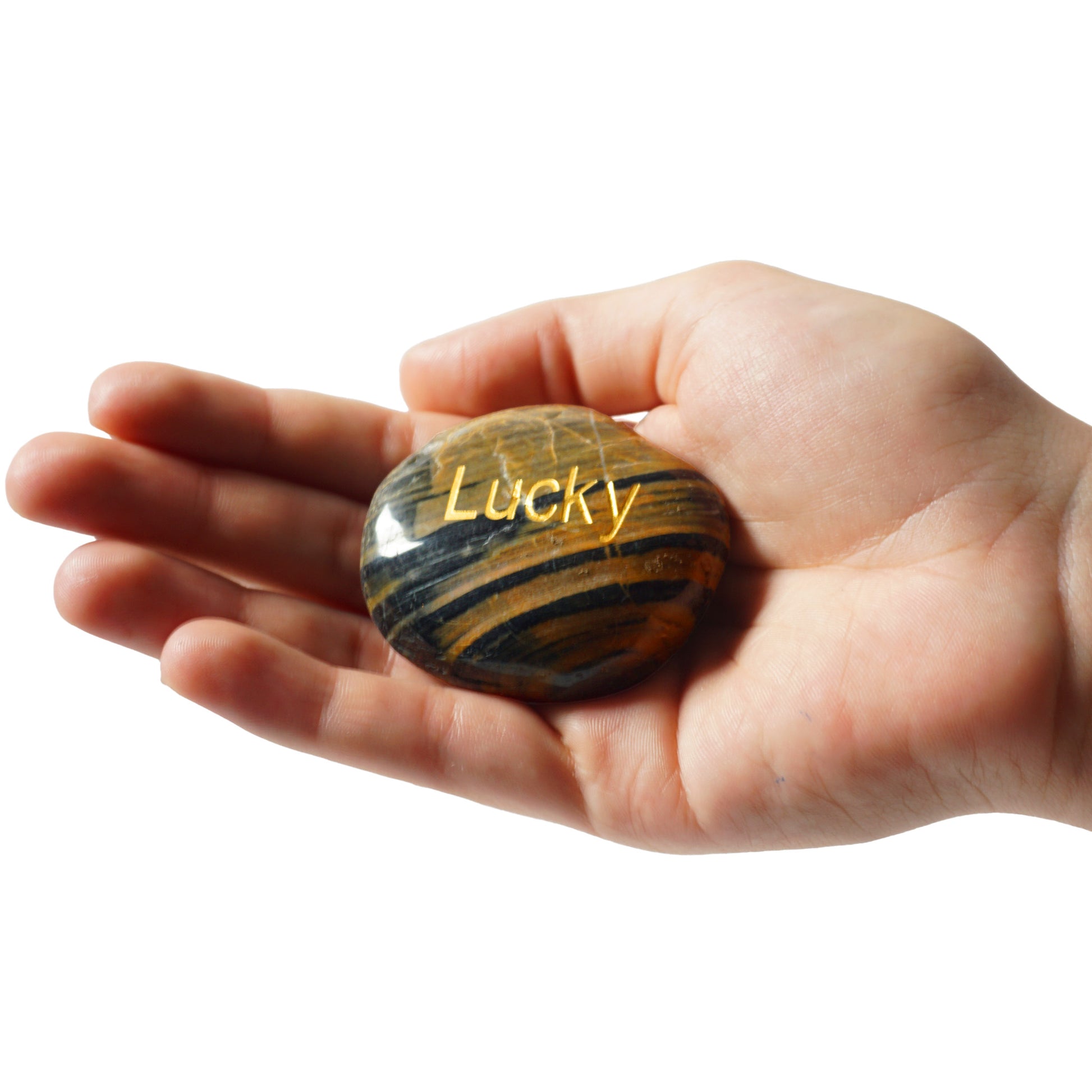 Hand holding a striped rock with 'Lucky' engraved on a white background
