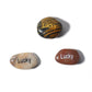 Three stones with 'Lucky' engraved on them on a white background