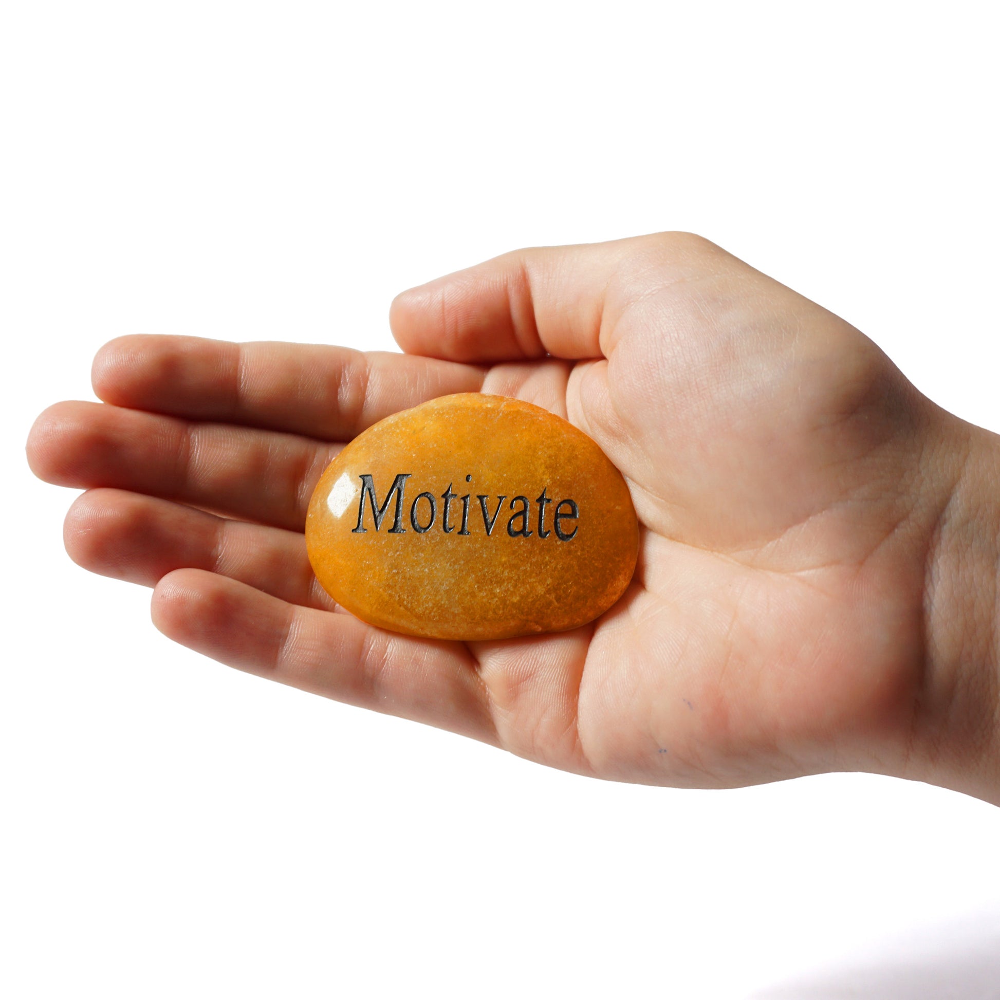 Hand holding a rock with 'Motivate' engraved on it against a white background
