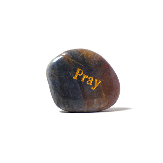 Polished stone with 'Pray' engraved on a white background