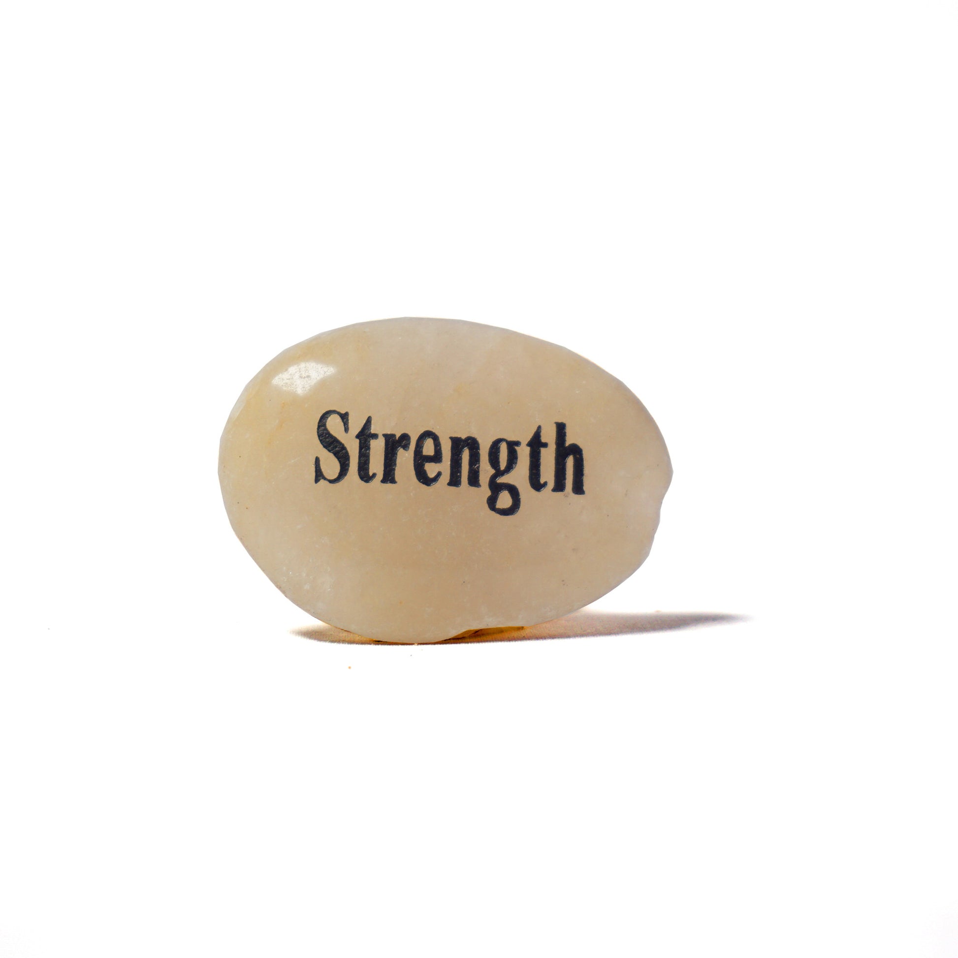 Rounded stone with 'Strength' engraved on a white background