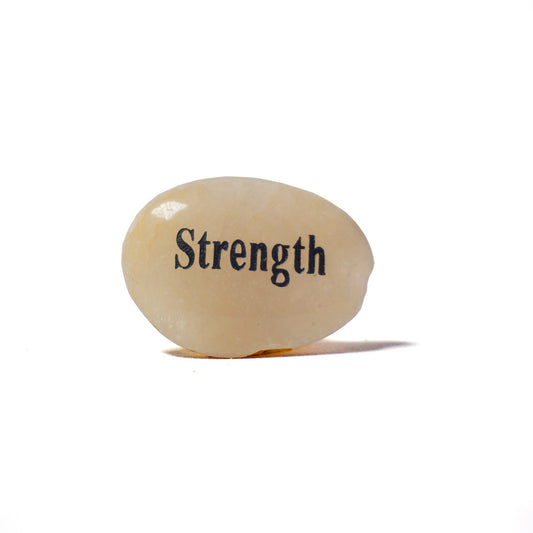 Rounded stone with 'Strength' engraved on a white background
