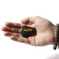 Hand holding a stone with 'Success' engraved on it against a white background