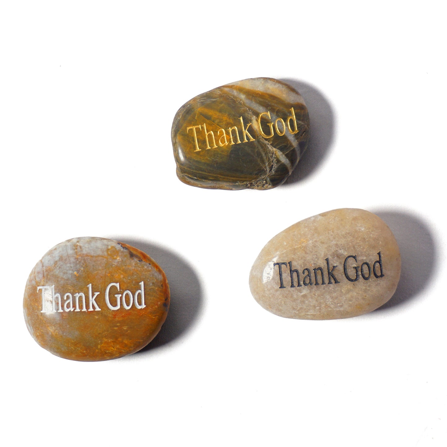 Three stones with 'Thank God' engraved on a white background