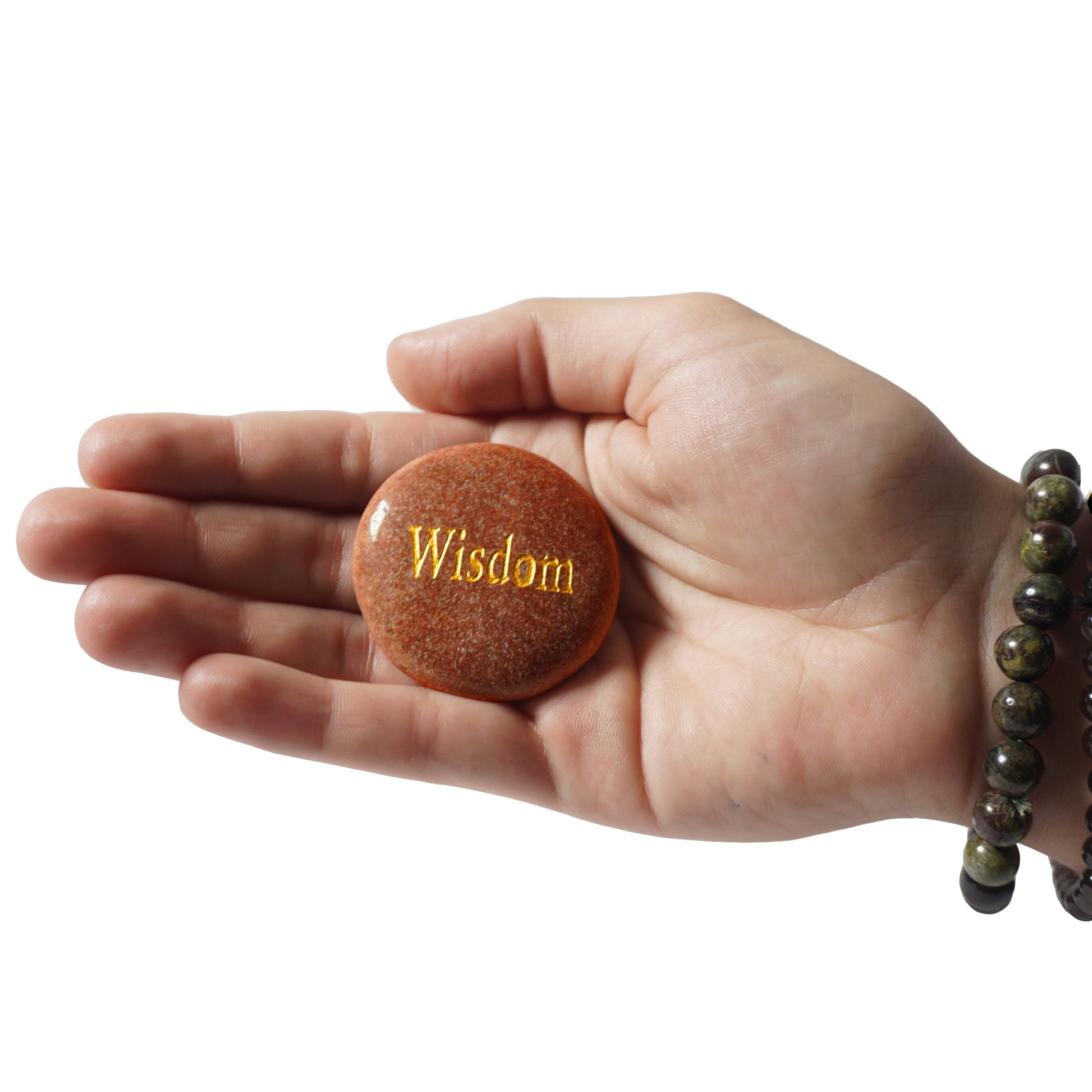 Hand holding a stone with 'Wisdom' engraved on it against a white background