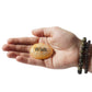 Hand holding a stone with 'Wish' engraved on it against a white background